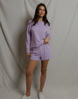 model wearing a purple lounge set on a white background