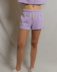 model wearing a purple lounge set on a white background