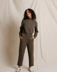 Person wearing a brown tracksuit against a plain background