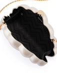 A scalloped cream faux-leather clutch bag with a black chevron-patterned interior lining and a gold chain strap, shown on a white background.