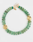 Green beaded bracelet with gold accents on a white background