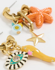 Set of colorful keychains with starfish, eye design, and other charms on a white background