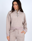 Woman wearing a beige tracksuit on a white background front view