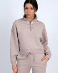 Woman wearing a beige tracksuit on a white background front view