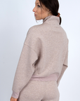 Woman wearing a beige tracksuit on a white background back view