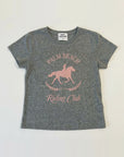 A heather gray short-sleeve t-shirt with a pink graphic print of a horse rider on a horse and the text 'PALM BEACH Riding Club' on the front, laid flat against a white background.