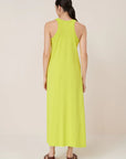 Woman wearing a bright yellow dress on a plain background, back