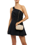 model with a clutch with crushed shells and gold details on a white background