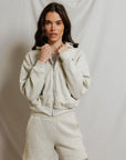 model wearing a zip up hoodie and lounge shorts in the color oatmeal