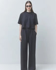 model wearing a black tshirt with black pants on a black background