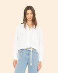 Woman wearing White Monroe Shirt and light blue jeans on a beige background