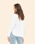 Woman wearing White Monroe Shirt and light blue jeans on a beige background