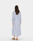 Woman wearing a long blue and white striped dress on a white background