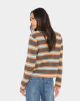 A woman shown from the back wearing a cropped, long-sleeve knit sweater with horizontal stripes in brown, beige, and light blue, paired with blue jeans, against a light gray studio background.