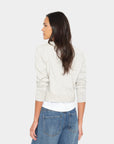 model wearing a grey cardigan over a white top with jeans on a white background, back view