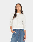 model wearing a grey cardigan over a white top with jeans on a white background