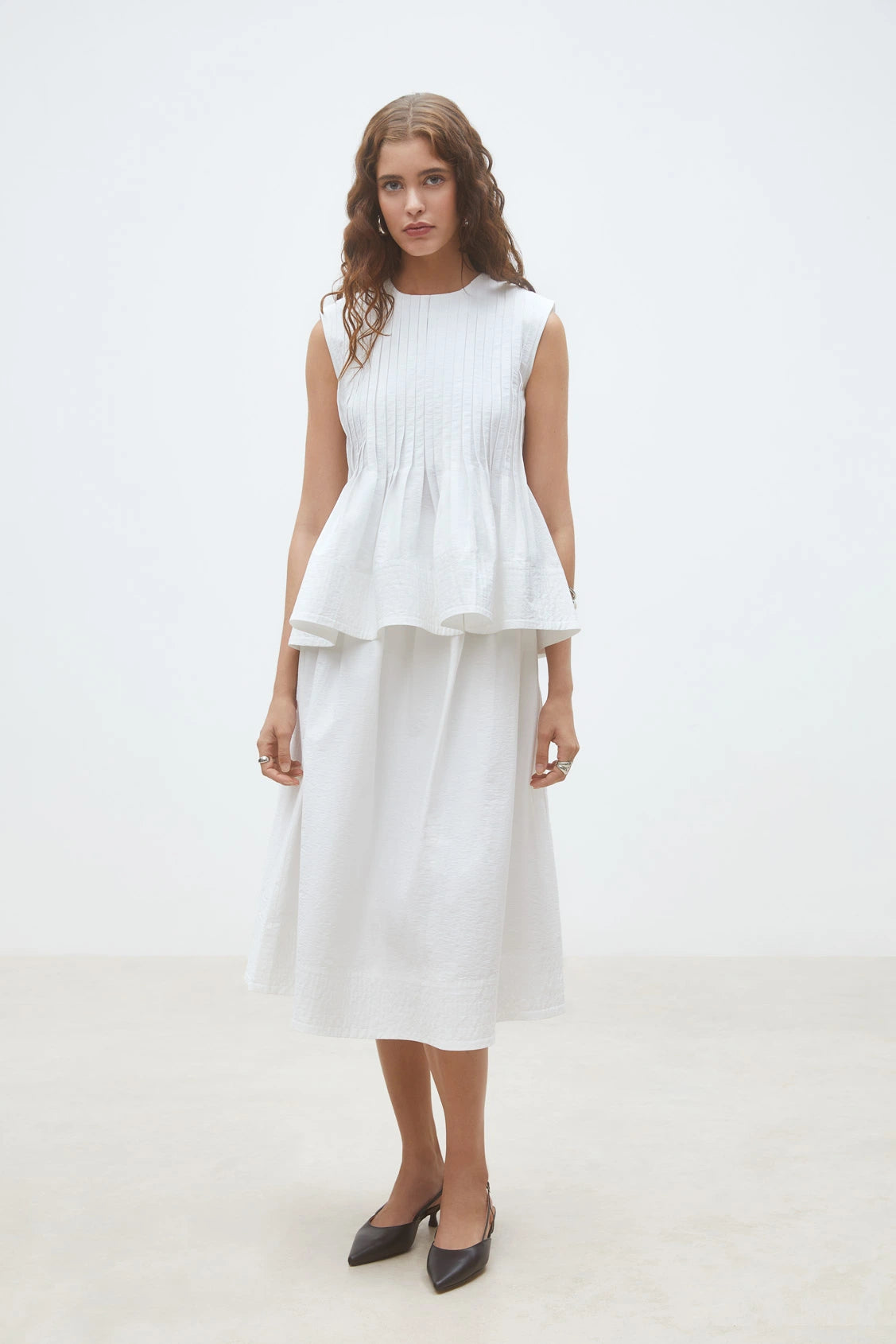 Luigi Sleeveless Pleat Top front view paired with white skirt