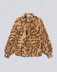 A long-sleeve blouse with a brown and beige tiger-stripe pattern, featuring a high gathered collar and a button-down front, laid flat against a light gray background.