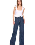 Woman wearing a white top and blue jeans on a white background, full body front