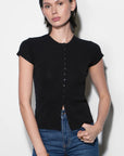 Woman wearing a black short-sleeve cardigan and blue jeans against a white background