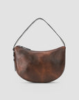A brown leather crescent-shaped shoulder bag with a single thin strap and a zippered top, shown against a light gray background.