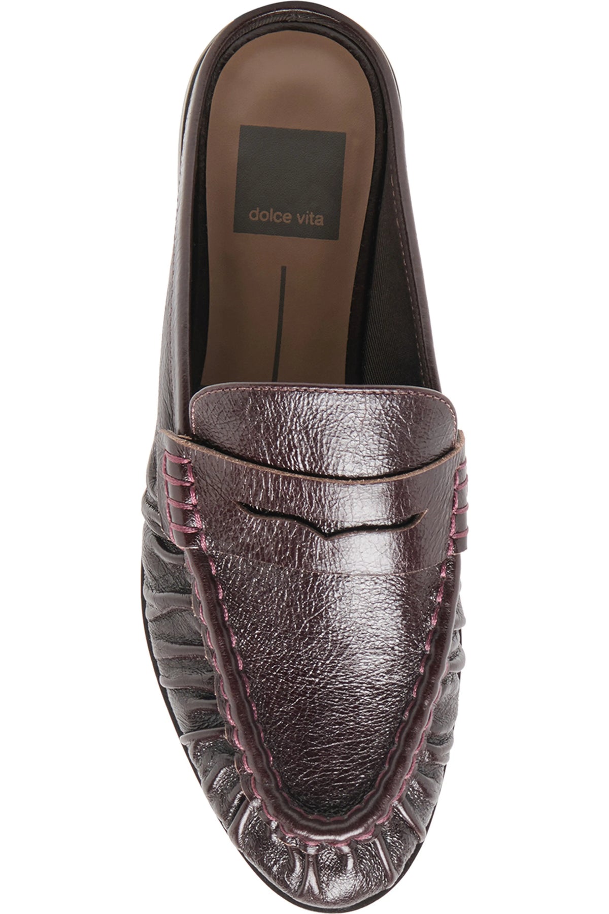 A single Dolce Vita leather loafer slip-on shoe in a dark brownish-purple hue, featuring textured leather, decorative stitching, and a pointed toe, shown from a top-down perspective on a white background.