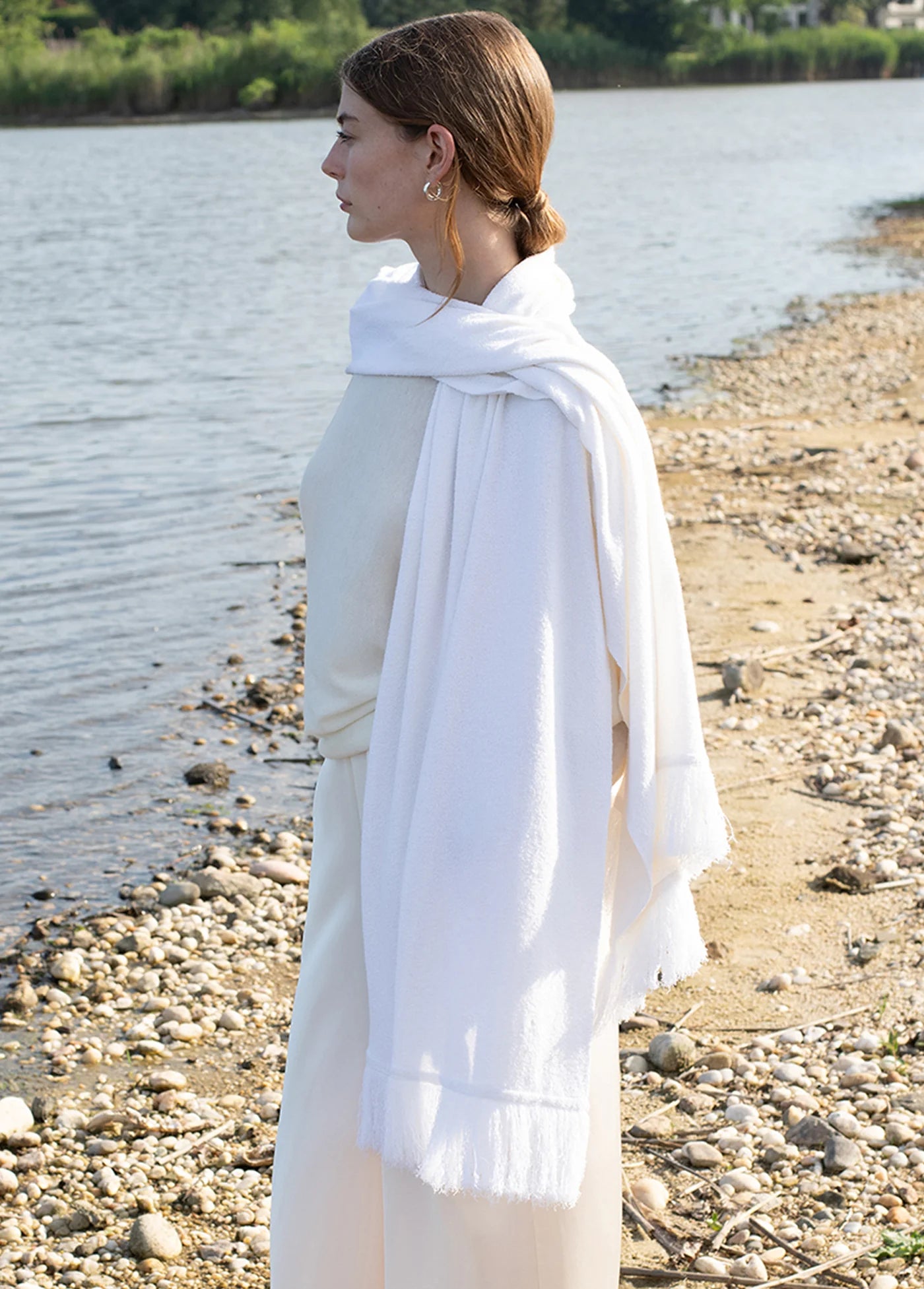 Woman wearing a white scarf by a body of water