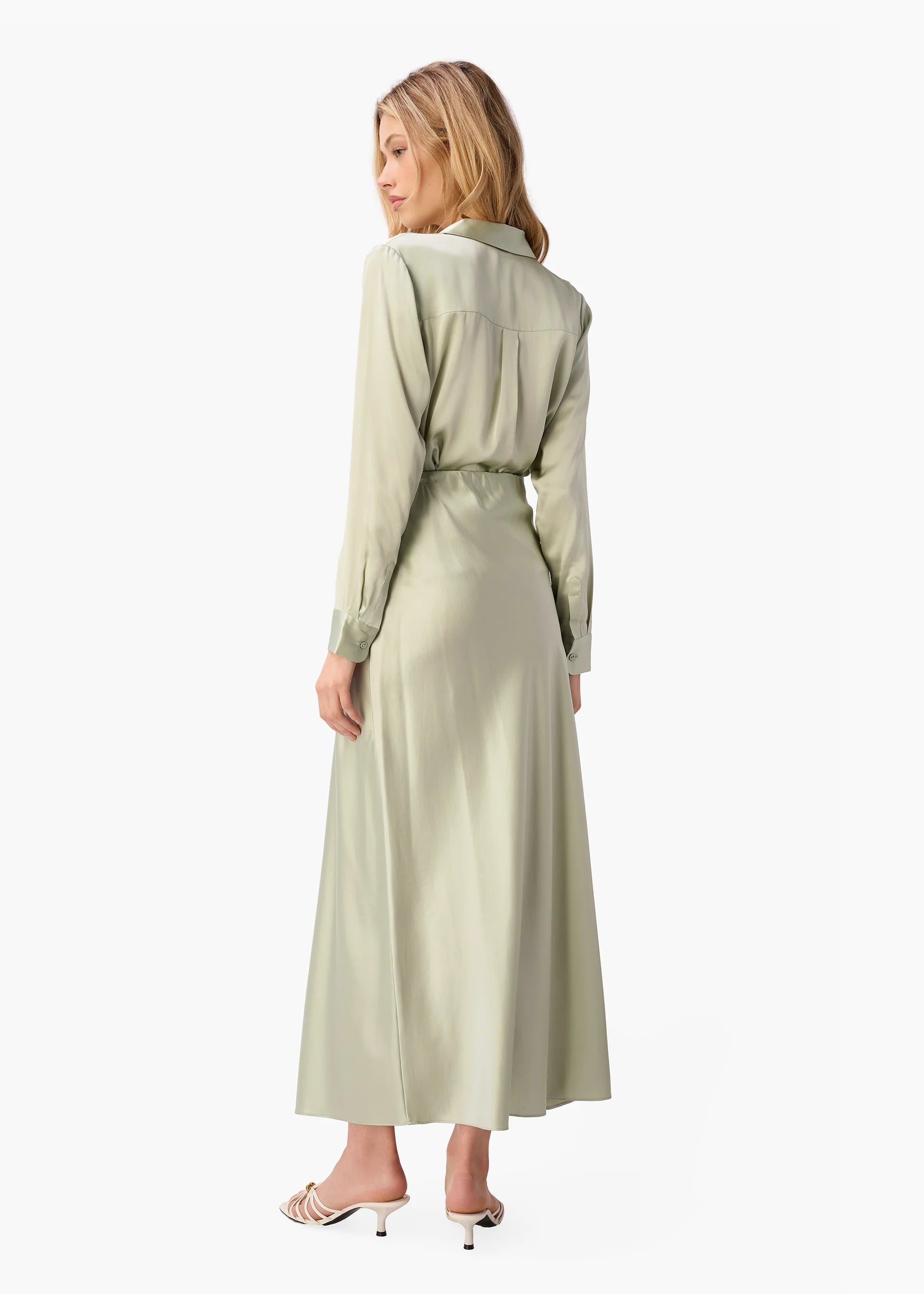 Woman wearing a long light green dress on a white background