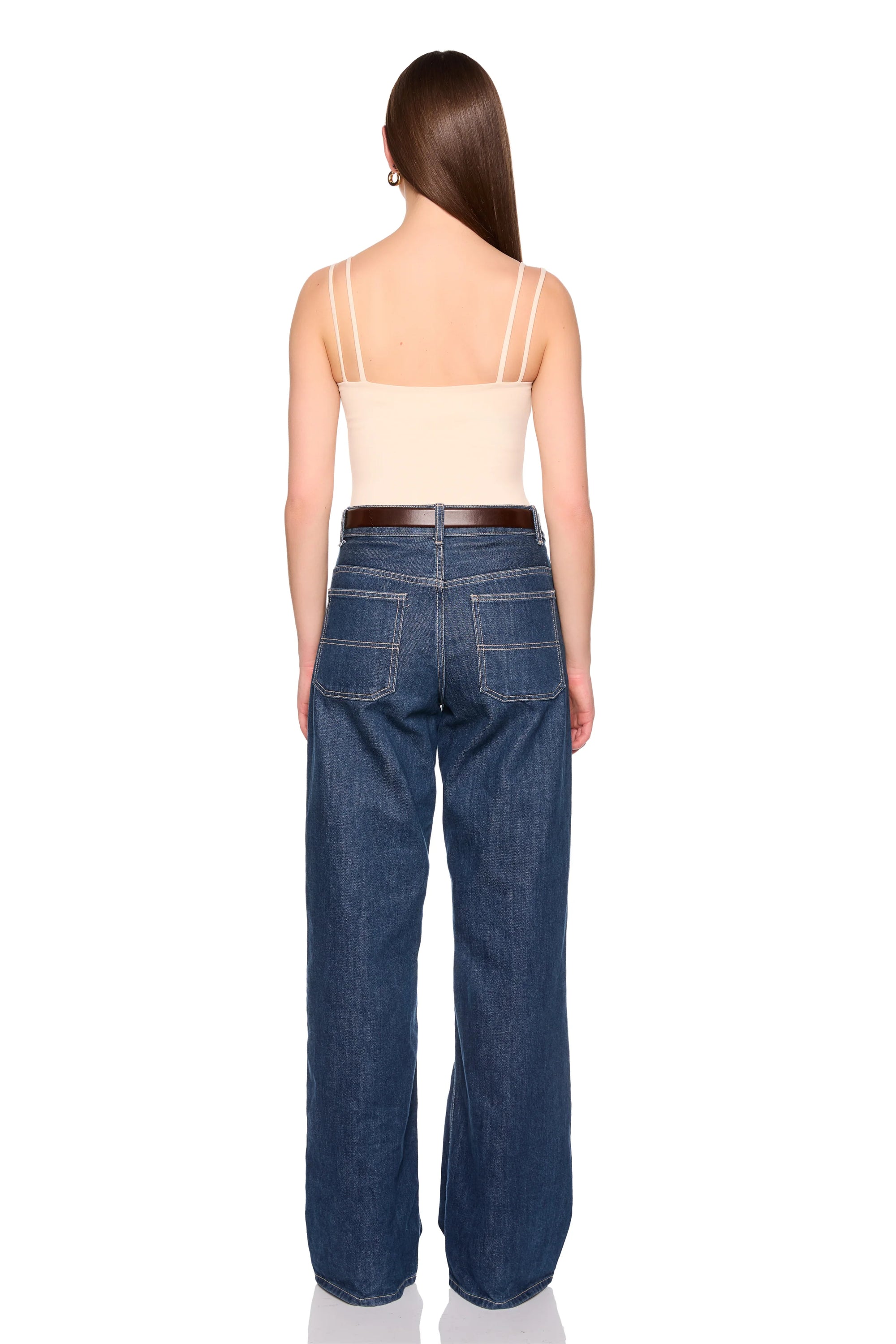 A woman shown from the back wearing dark blue wide-leg jeans, a brown belt, and a light beige camisole top against a plain white background.