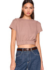 model wearing coco tee gathered at waist with jeans on a white background