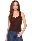 A woman modeling a dark brown sleeveless henley tank top with blue jeans against a plain white background.