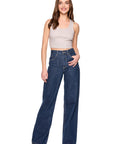 Woman wearing blue jeans and a beige top on a white background