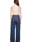 Person wearing blue jeans and a white top on a white background