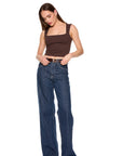A woman modeling a brown square-neck crop top and wide-leg blue jeans with a brown belt, standing against a solid white background. full body front