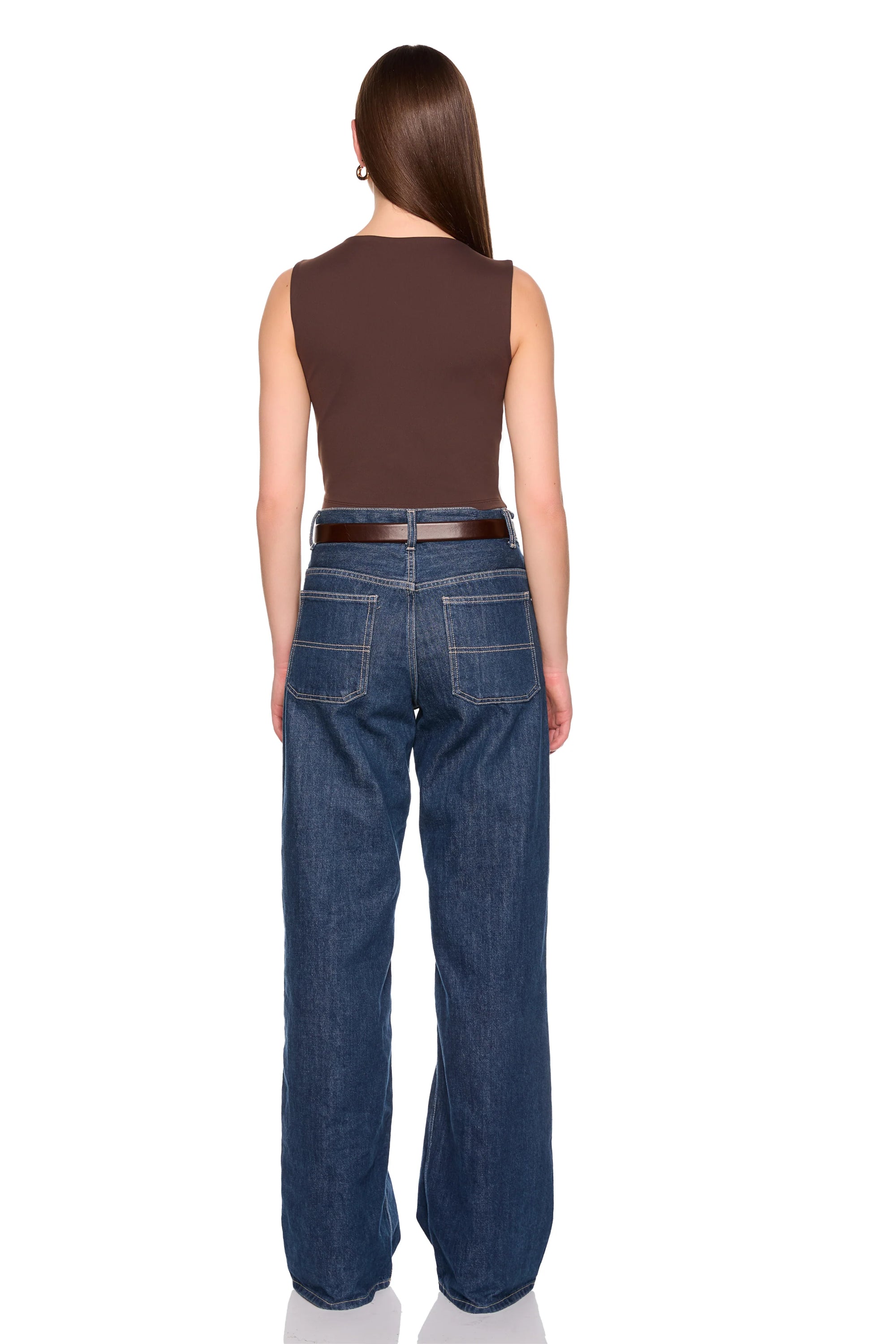 A woman shown from the back wearing a brown sleeveless top, a thin brown belt, and wide-leg blue jeans against a plain white background.