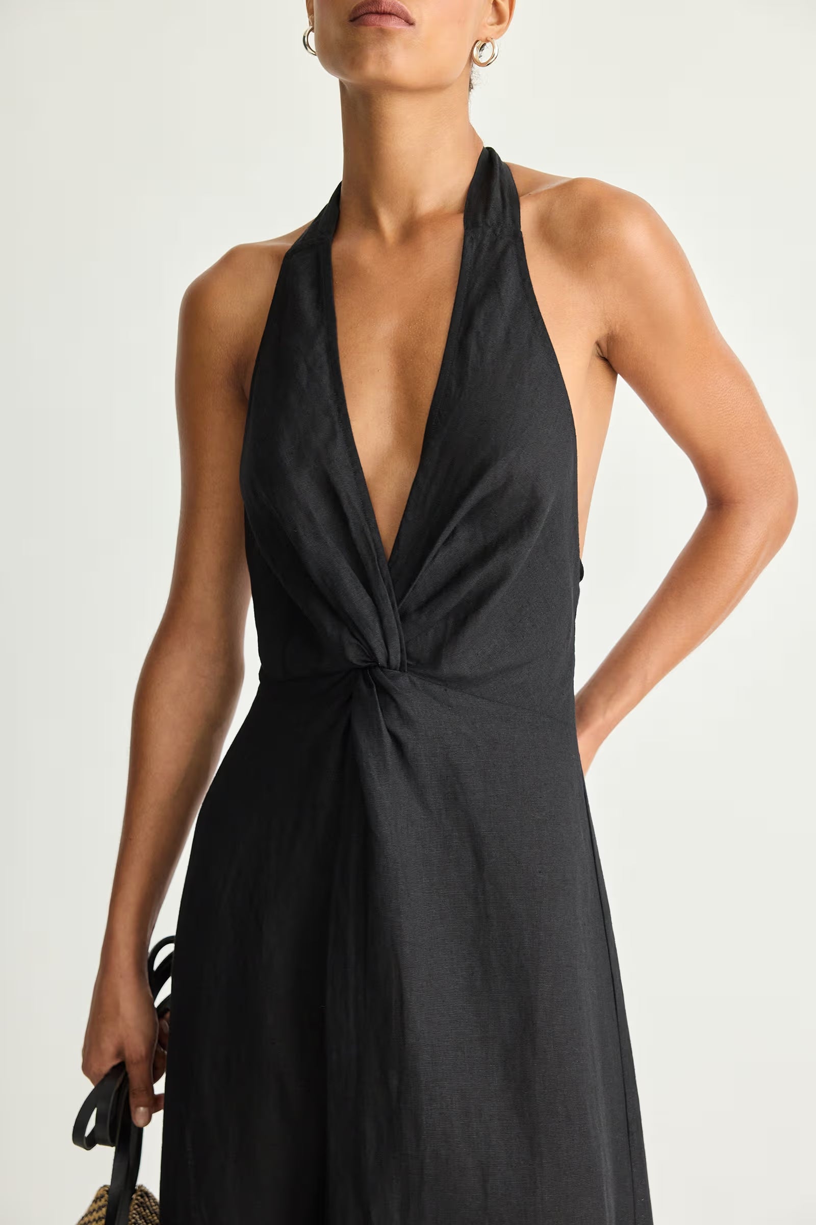Black halter neck dress worn by a model on a white background