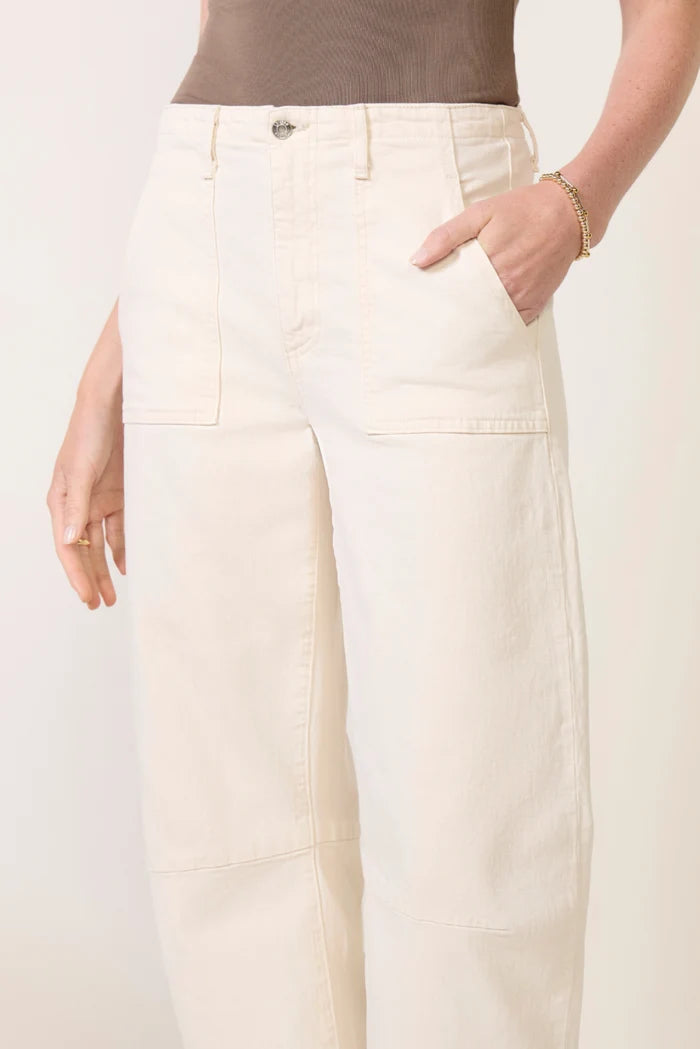 model wearing a bone colored utility jean / pant with a brown tank on a white background 