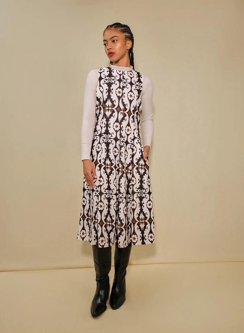 Woman wearing a patterned dress with a plain background
