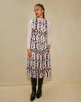 Woman wearing a patterned dress with a plain background