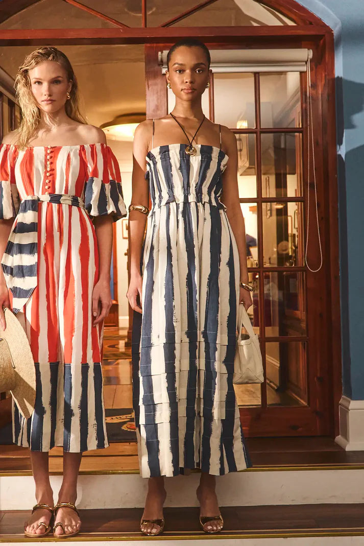 Two women wearing striped dresses standing in a doorway.