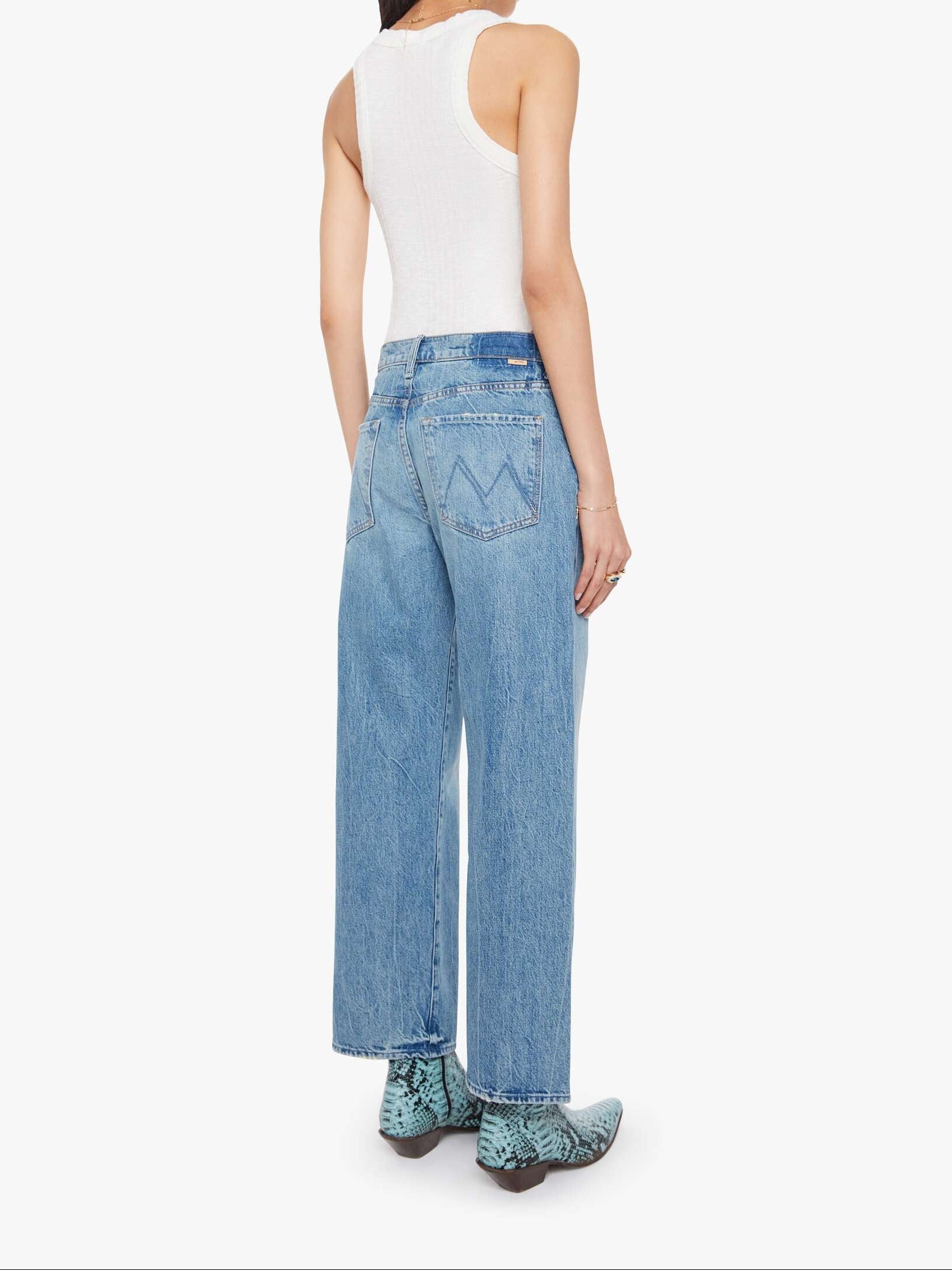 Woman wearing light blue jeans on a white background