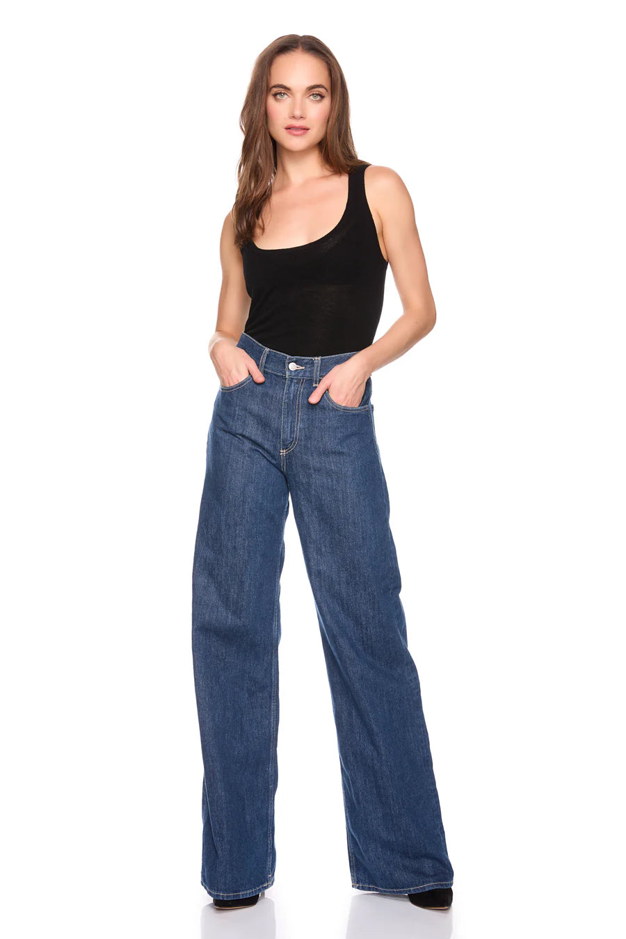 Woman wearing blue jeans and a black tank top on a white background