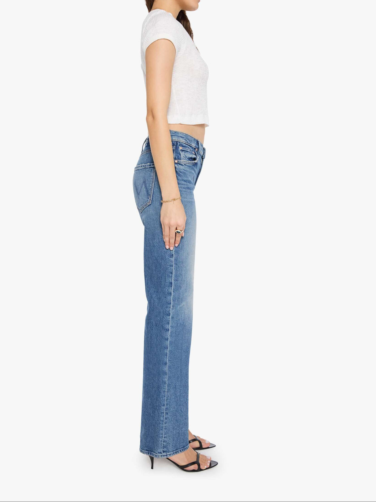 Woman wearing a white top and blue jeans on a white background