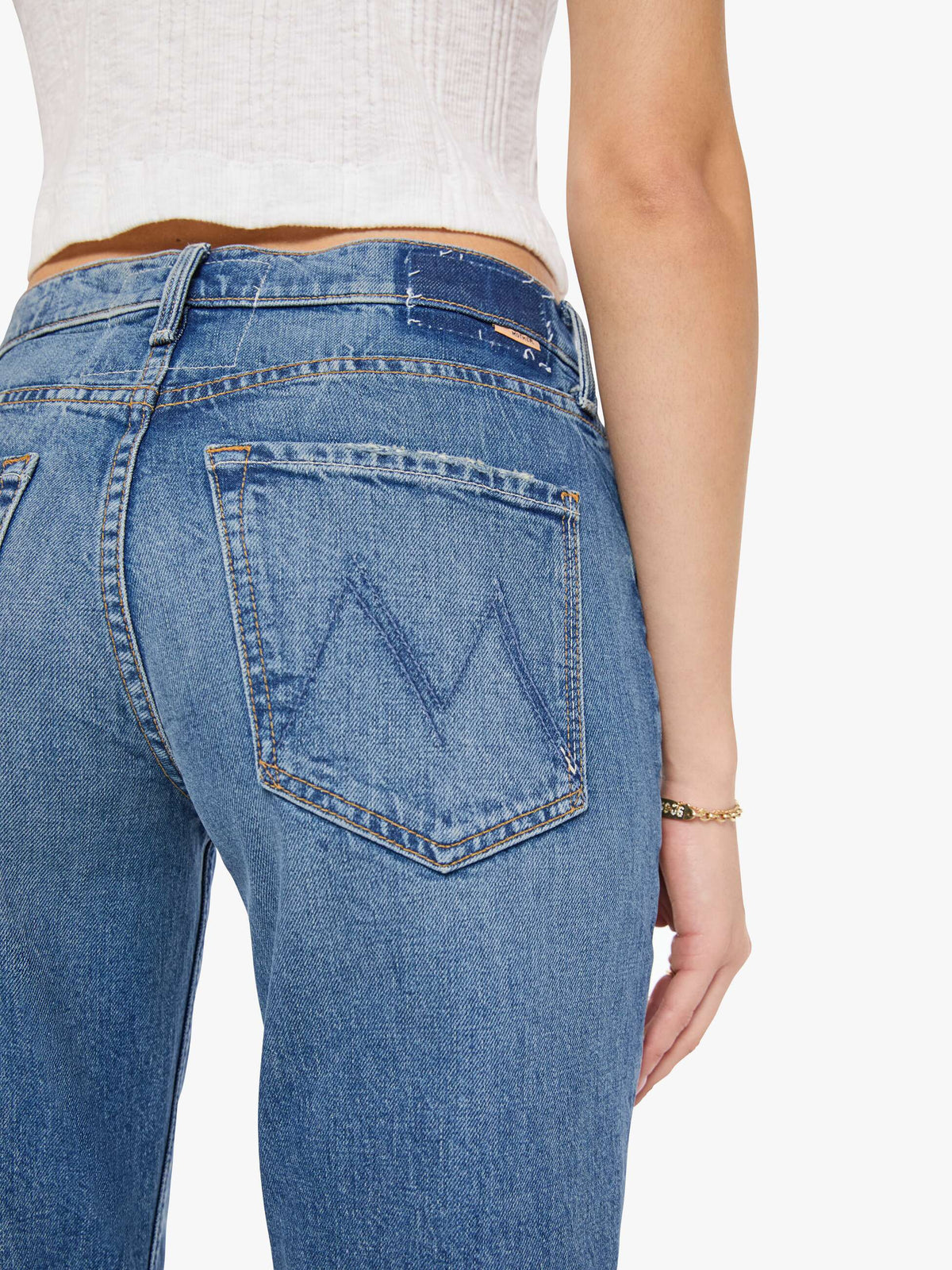 Close-up of blue jeans with a brand logo on a white background