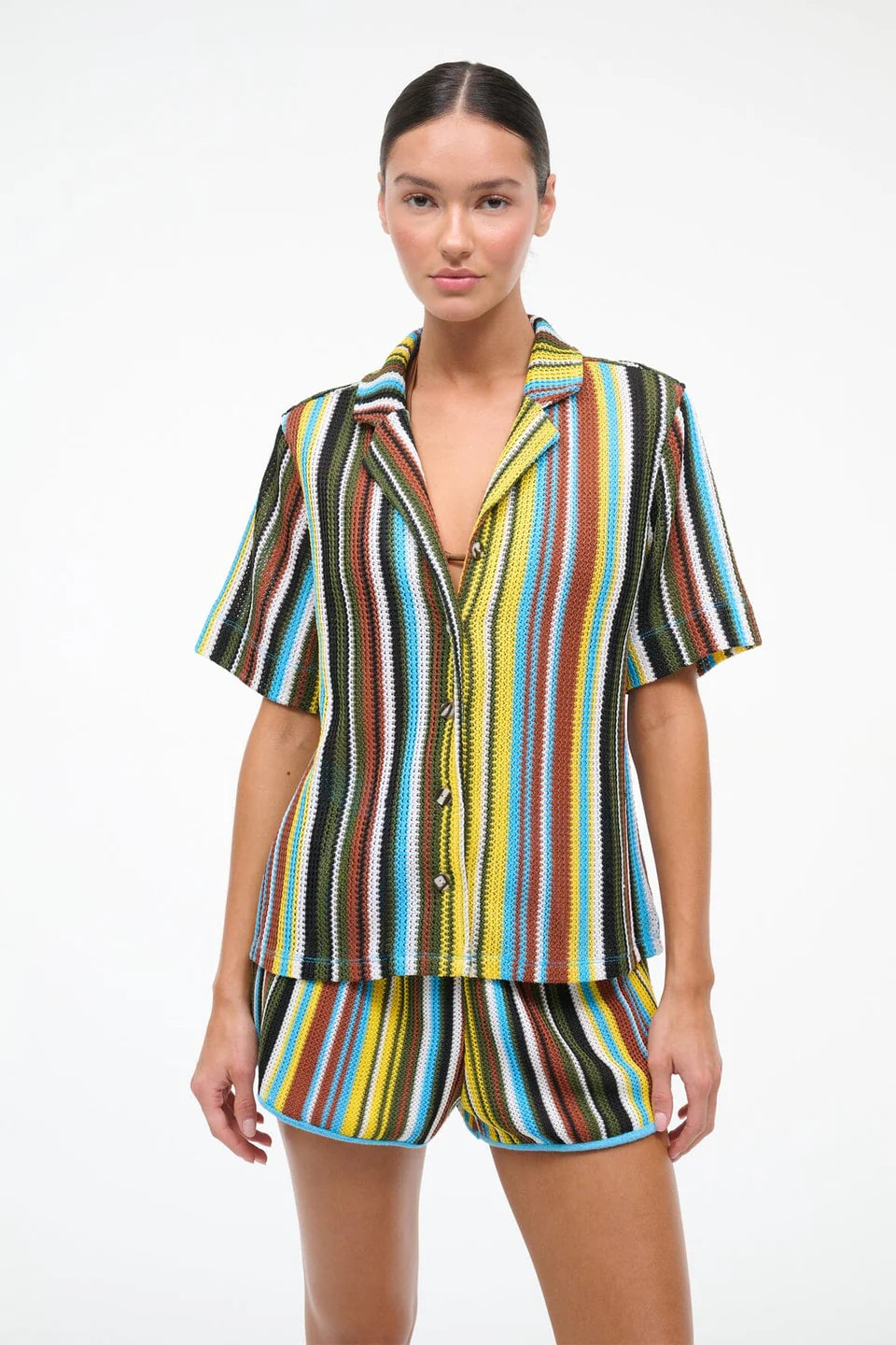 Woman wearing a colorful striped shirt and shorts set on a white background