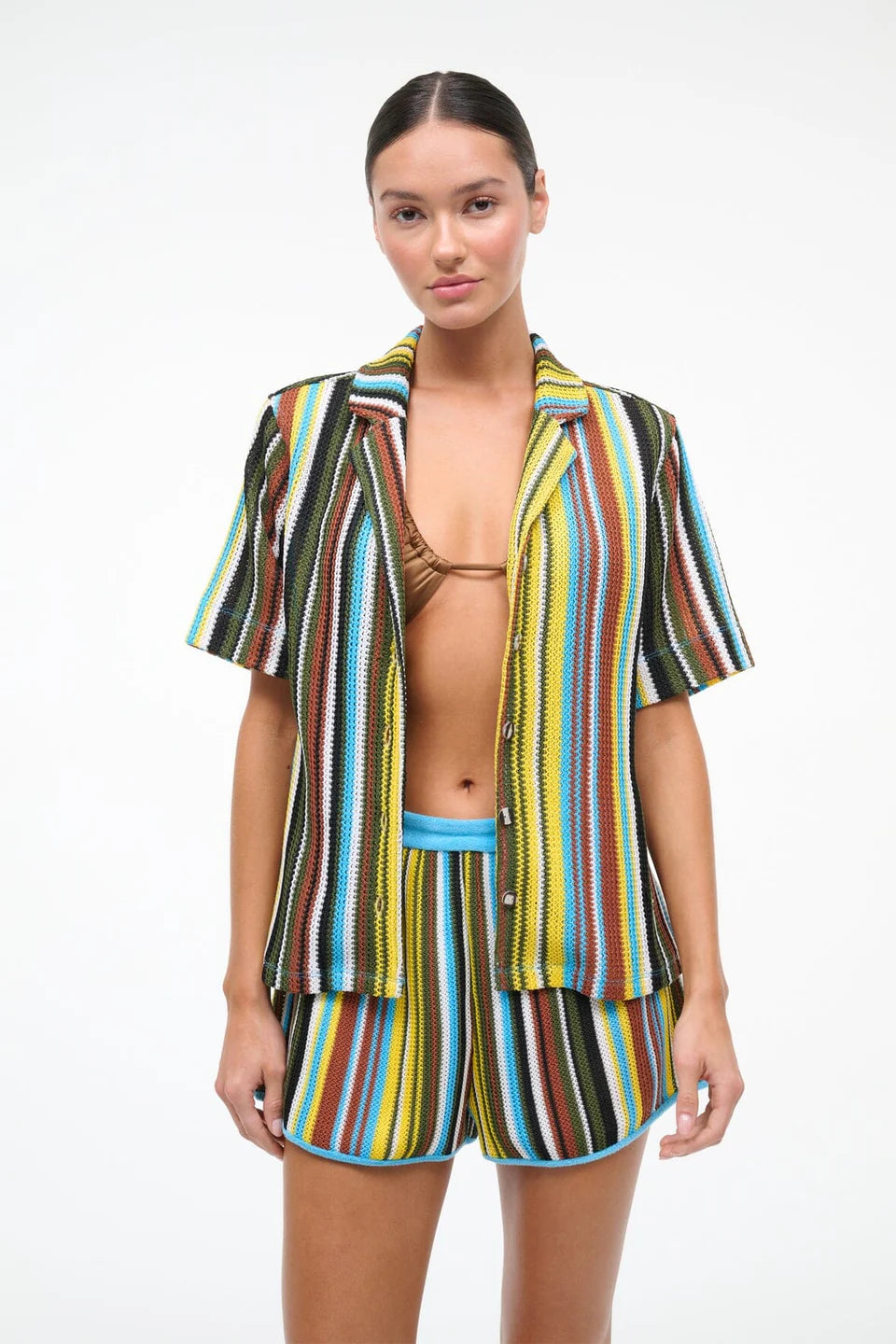 Woman wearing a colorful striped outfit with a white background