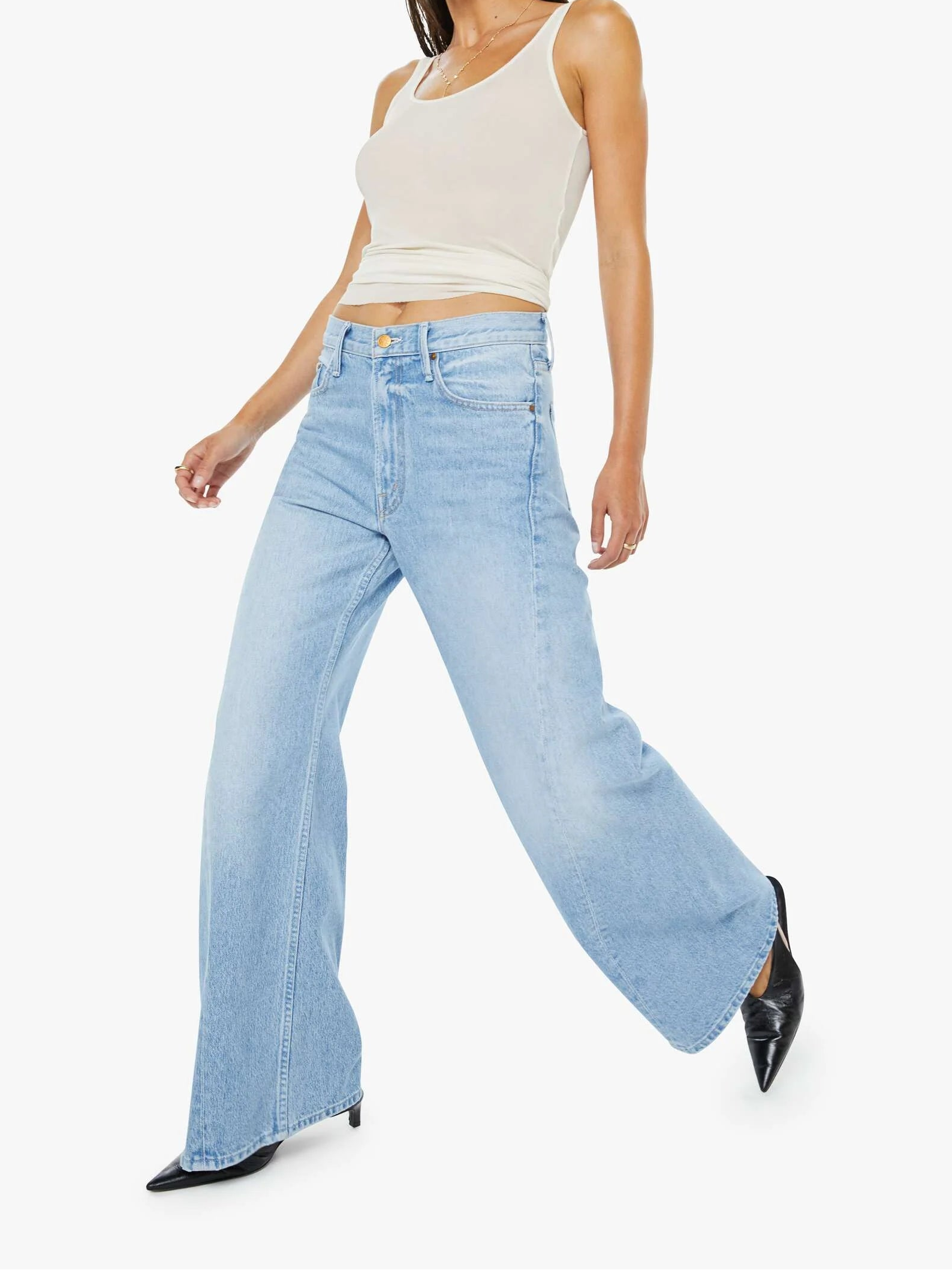 Woman wearing light blue jeans and a white top on a white background