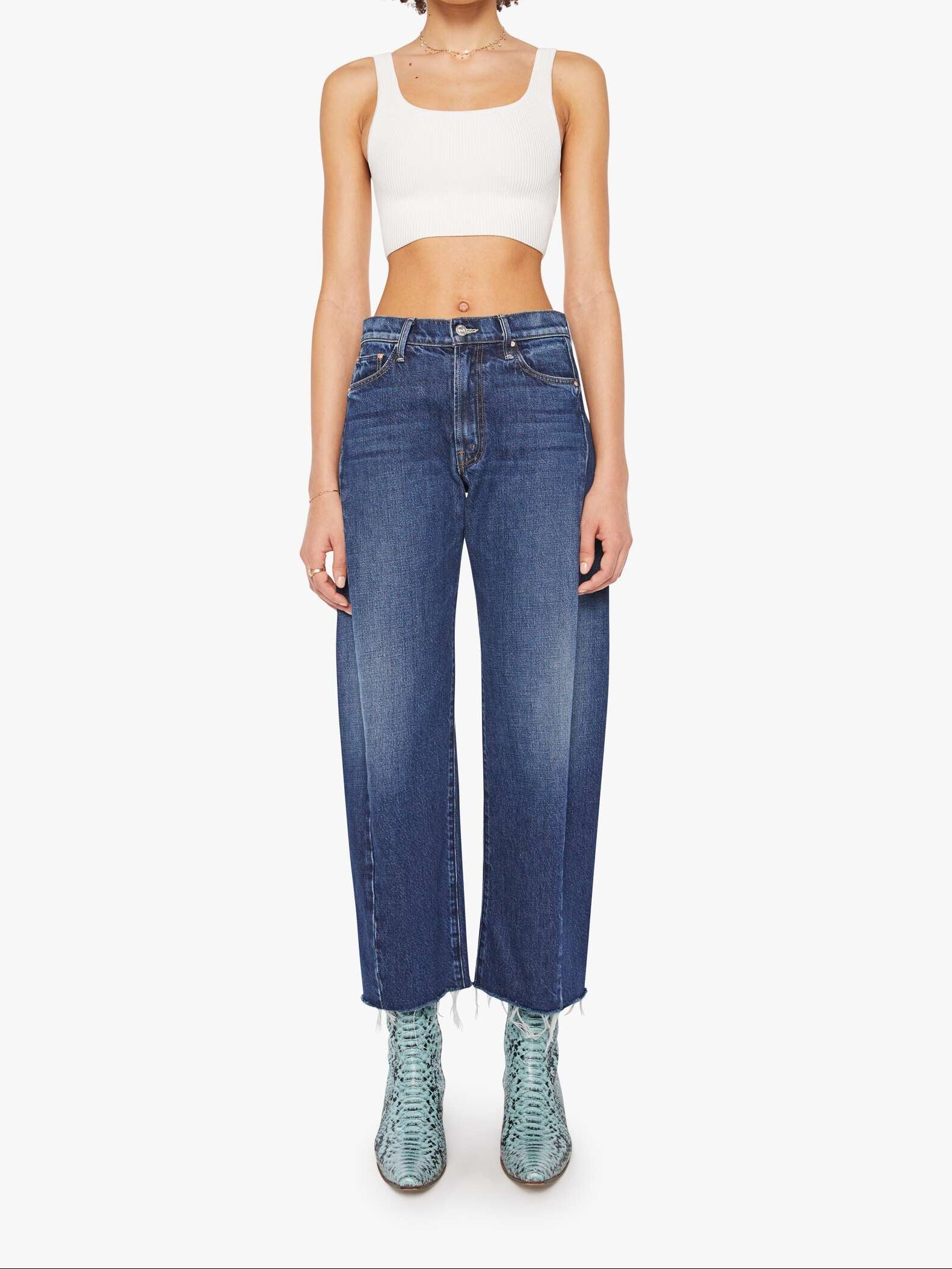 Woman wearing blue jeans and a white top on a white background