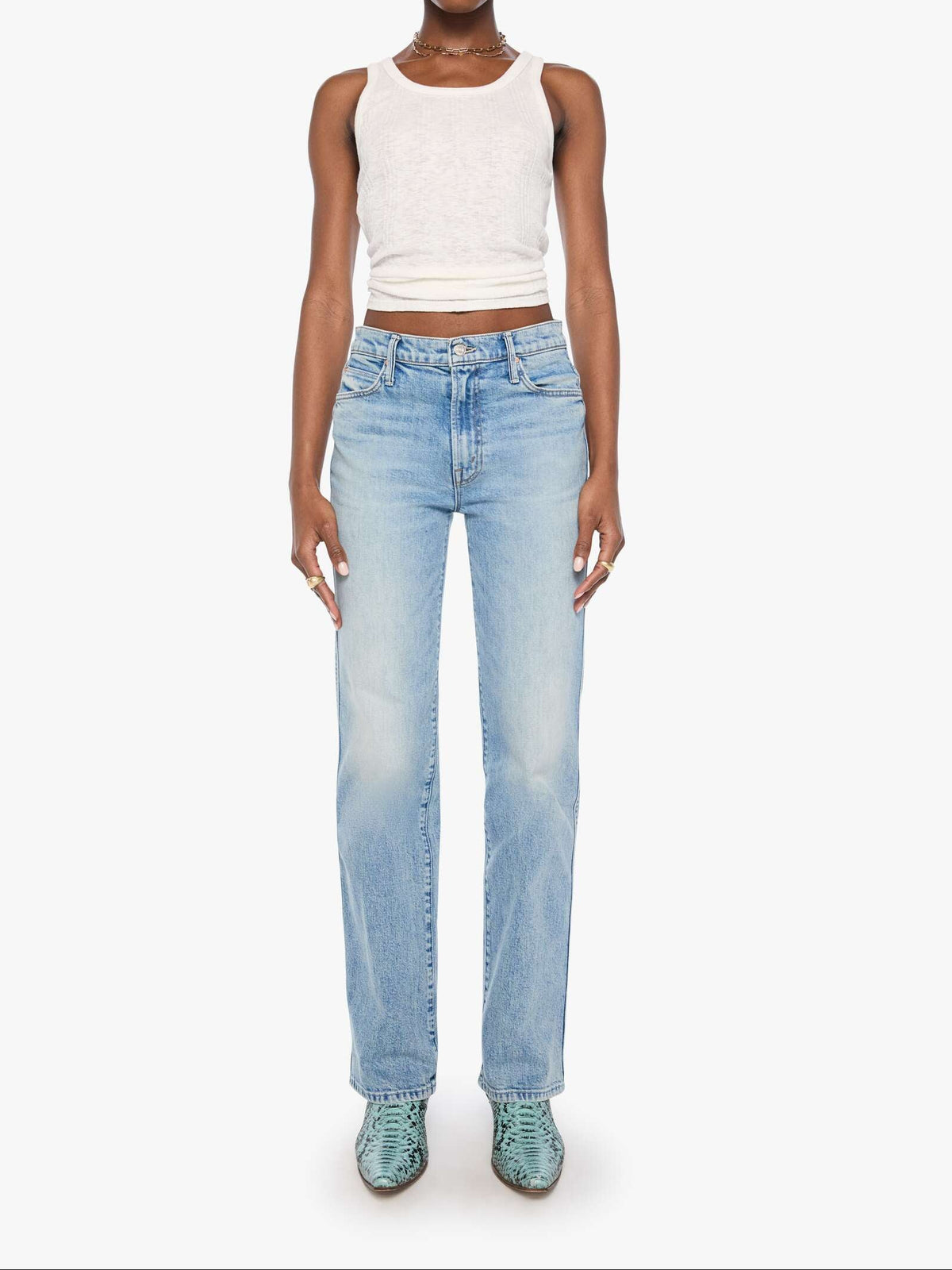 Woman wearing light blue jeans and a white top on a white background