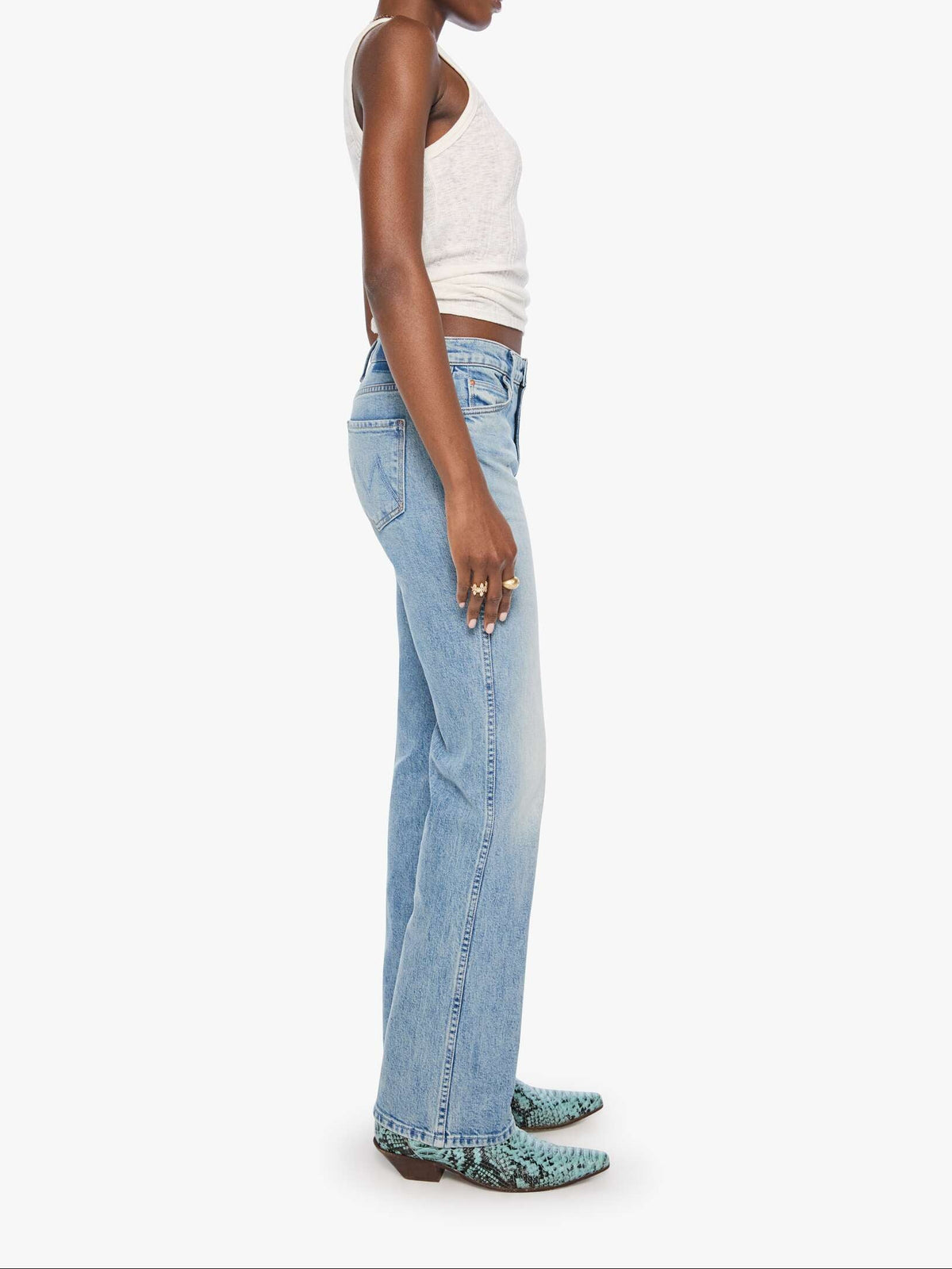 Woman wearing light blue jeans and a white top on a white background
